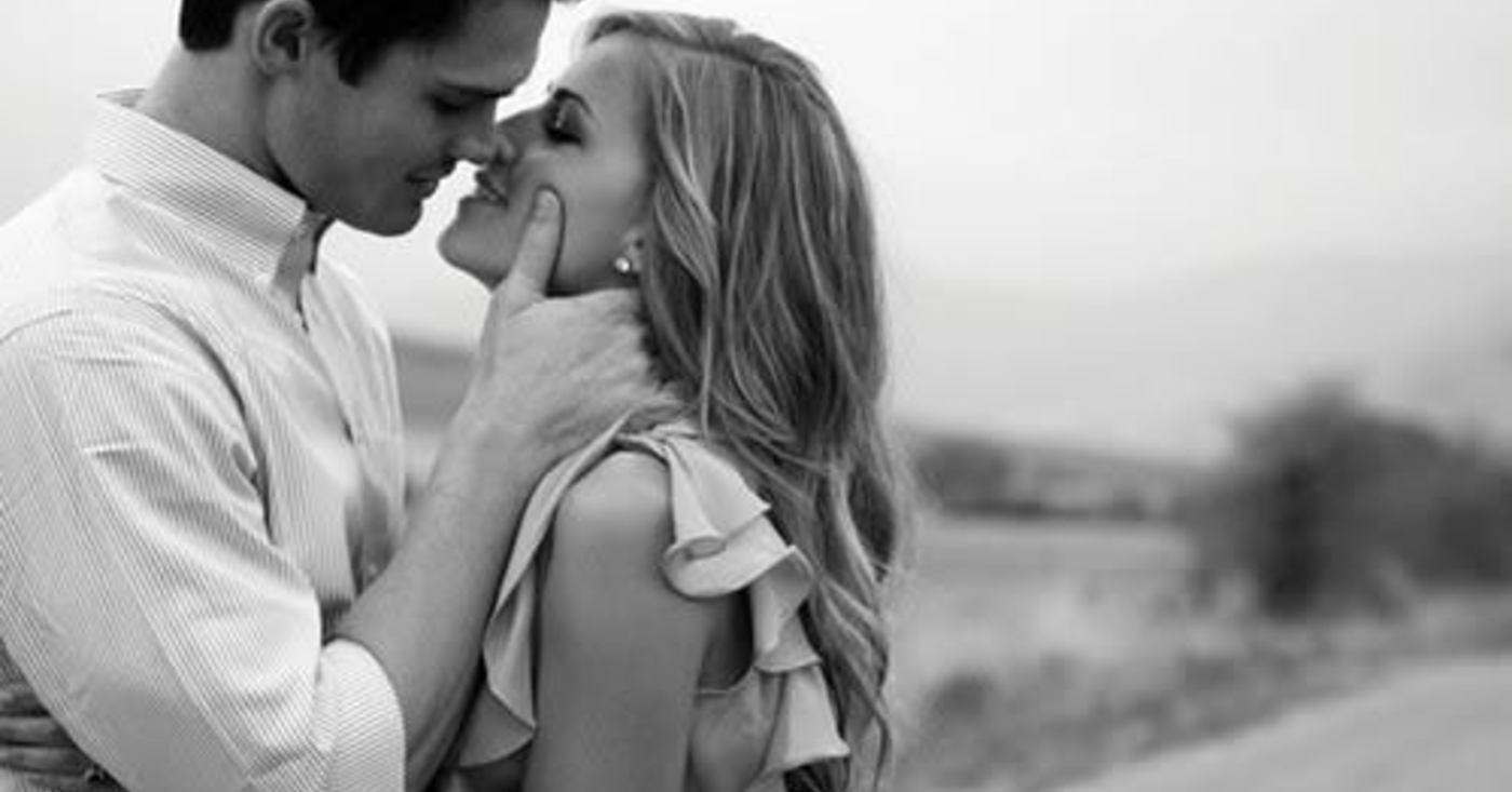 Парень целует девушку держа за лицо